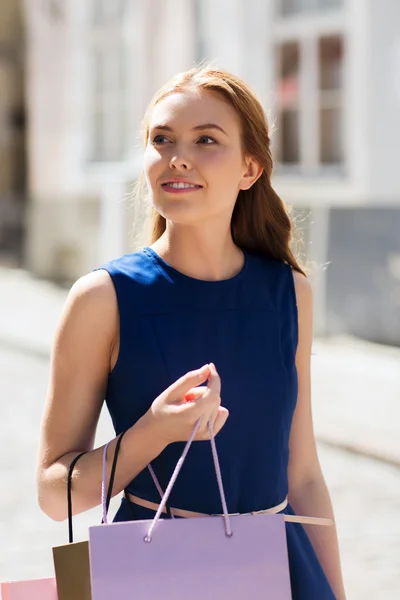 Mulher feliz com sacos de compras andando na cidade — Fotografia de Stock