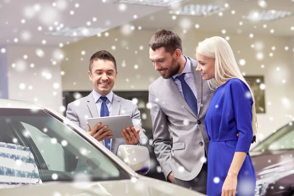 Couple heureux avec concessionnaire de voitures en salon ou salon de l'auto — Photo