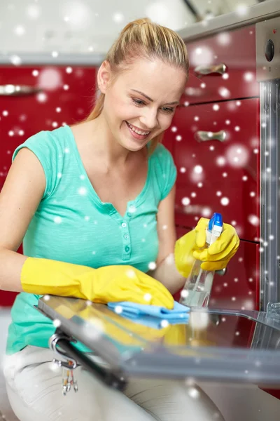 Mulher feliz limpeza fogão em casa cozinha — Fotografia de Stock