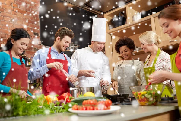 happy friends and chef cook cooking in kitchen