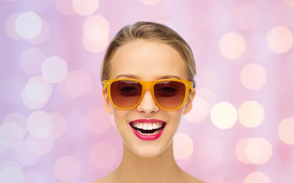 Heureuse jeune femme en lunettes de soleil avec rouge à lèvres rose — Photo