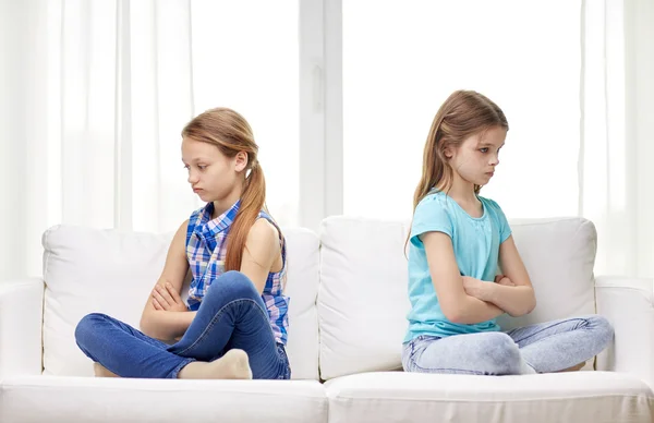 Quarreled little girls sitting on sofa at home — Stockfoto