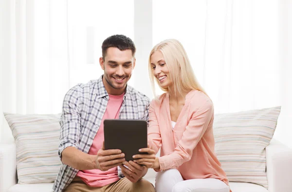 Sorrindo casal feliz com tablet pc em casa — Fotografia de Stock