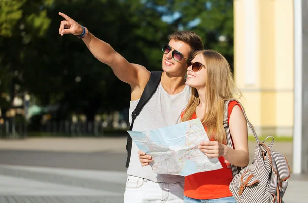 Couple souriant avec carte et sac à dos en ville — Photo