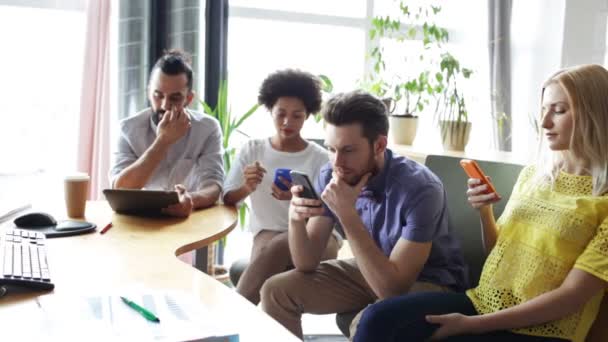 Decisão erradasquadra di affari con smartphone e tablet pcWirtschaft, Menschen, Technik und Team arbeiten Konzept - Nahaufnahme von kreativ-Team mit Smartphones und tablet-pc-Computer sitzend am Tisch im Büro — Stock video