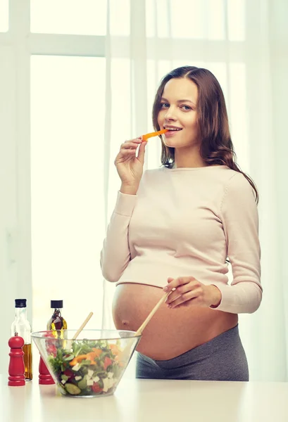 Mujer embarazada feliz preparando comida en casa — Foto de Stock