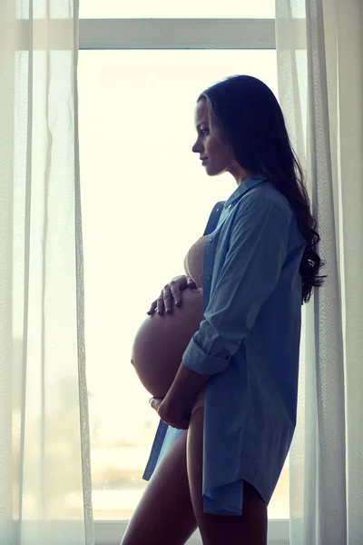 Щаслива вагітна жінка з великим голим животом вдома — стокове фото