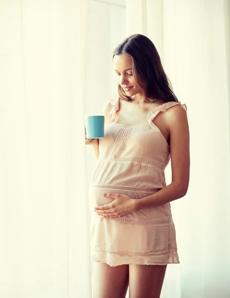 Mujer embarazada feliz con taza de té en casa — Foto de Stock