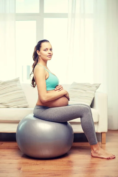 Mulher grávida feliz exercitando em fitball em casa — Fotografia de Stock