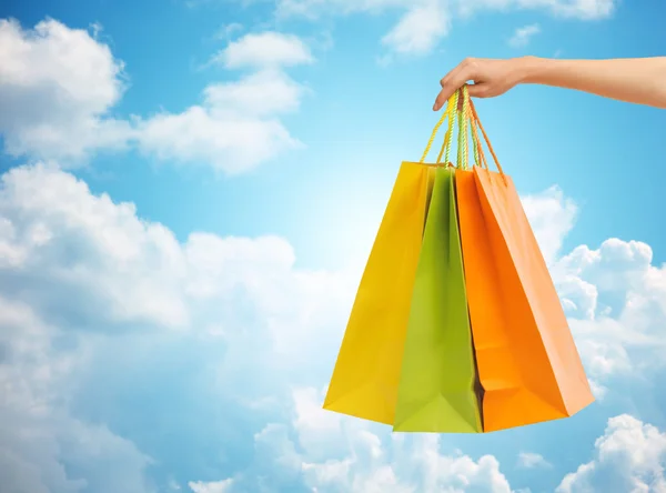 Close up of hand holding shopping bags — Stock Photo, Image