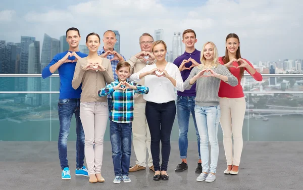 People showing heart hand sign over city waterside — Stockfoto