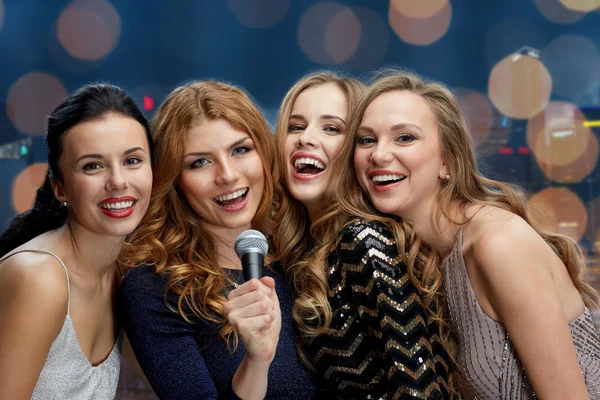 Glada unga kvinnor med mikrofon sjunga karaoke — Stockfoto
