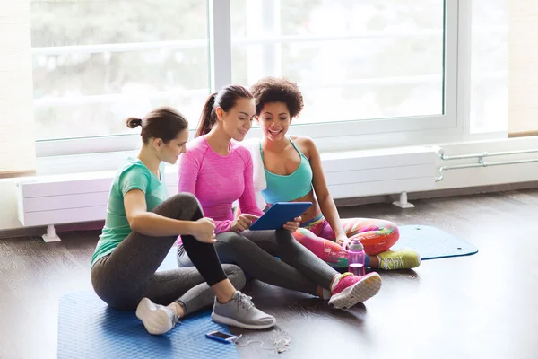 Gruppo di donne felici con tablet pc in palestra — Foto Stock