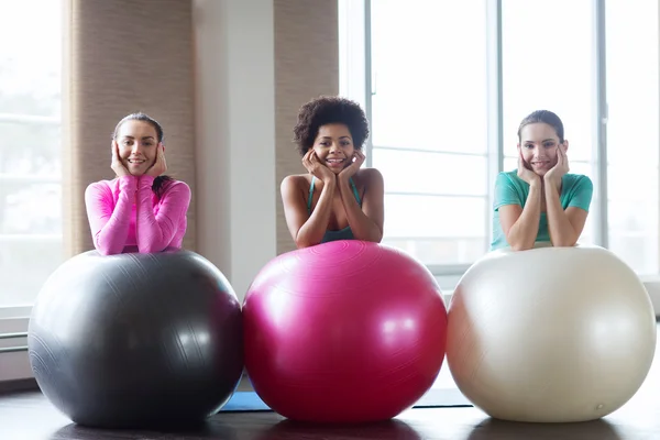 Grupo de mujeres sonrientes con bolas de ejercicio en el gimnasio — Foto de Stock