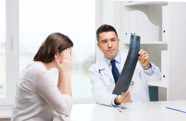 Sorridente médico masculino em casaco branco olhando para raio-x — Fotografia de Stock