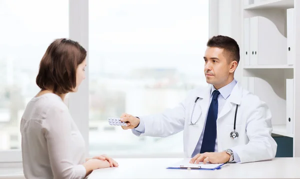 Doctor giving pills to woman at hospital — Stock Photo, Image