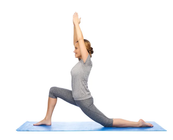 Happy woman making yoga in low lunge on mat — Stock Photo, Image