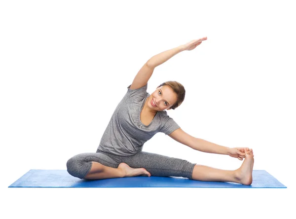 Happy woman making yoga and stretching on mat — Stock Photo, Image