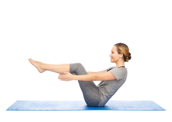 Vrouw yoga maken in half-boot pose op de mat — Stockfoto