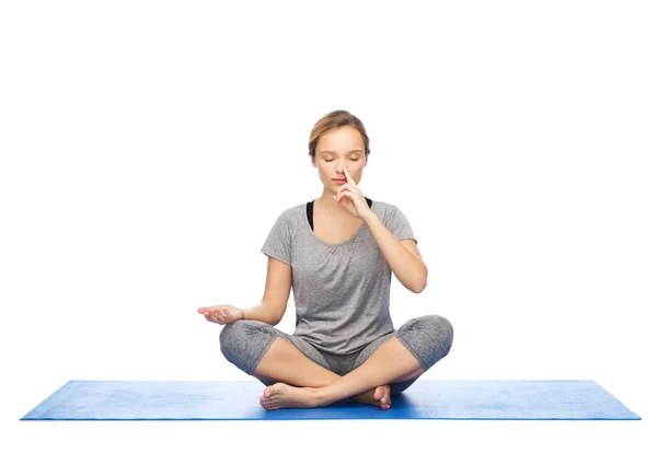 Kvinna att göra yoga meditation i lotus pose på matta — Stockfoto