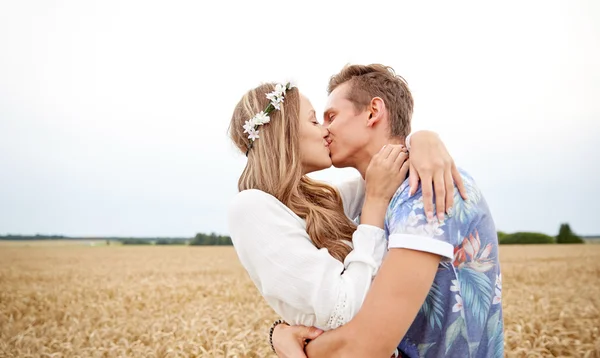 Happy young hippie couple kissing in field — Stock Photo, Image