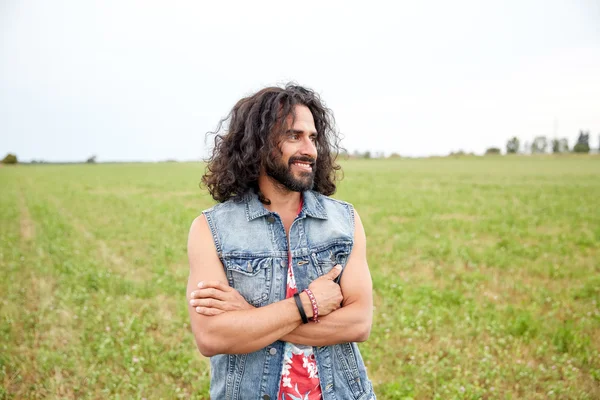 Smiling young hippie man on green field — Stock Photo, Image