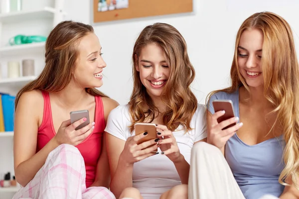 Друзья или девочки-подростки со смартфоном дома — стоковое фото