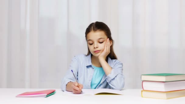 Chica de la escuela aburrida con libros y bloc de notas en casa — Vídeos de Stock