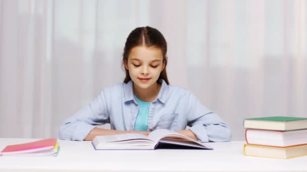 Chica de la escuela feliz lectura libro o libro de texto en casa — Vídeos de Stock