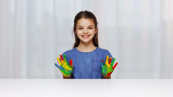 Усміхнена дівчина показує розфарбовані руки — стокове відео