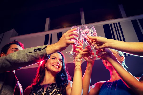 Amigos sonrientes con copas de champán en el club —  Fotos de Stock