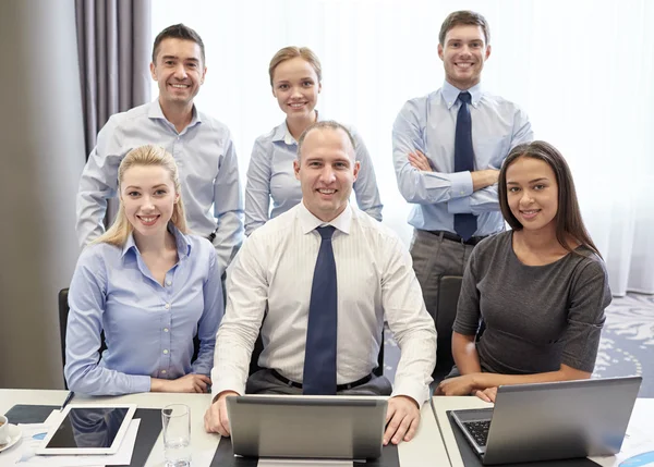 Smiling business people with laptop in office — Stock Photo, Image