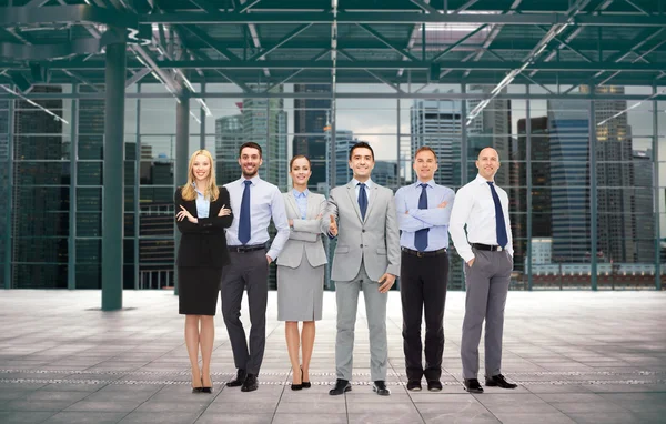 Группа улыбающихся бизнесменов над офисной комнатой — стоковое фото