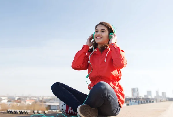 Happy young woman in headphones listening to music — Stock Photo, Image