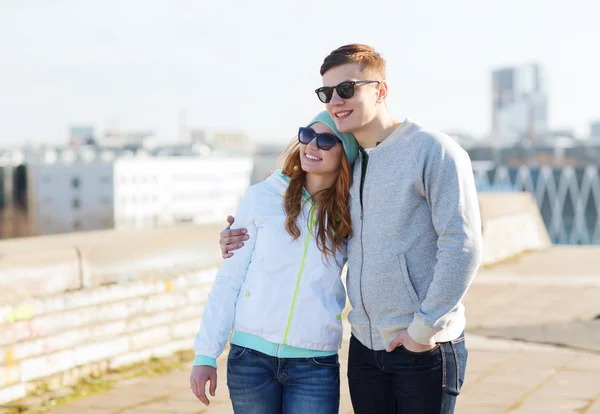 Happy teenage couple walking in city — Stock Photo, Image