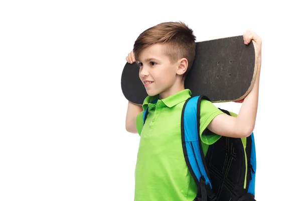 バックパックとスケートボードを持つ幸せな学生の男の子 — ストック写真