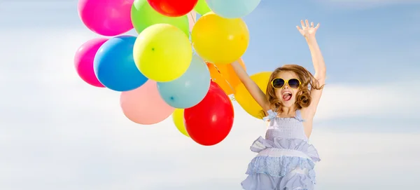 Happy jumping girl with colorful balloons — Stock Photo, Image