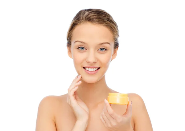 Happy young woman applying cream to her face — Stock Photo, Image