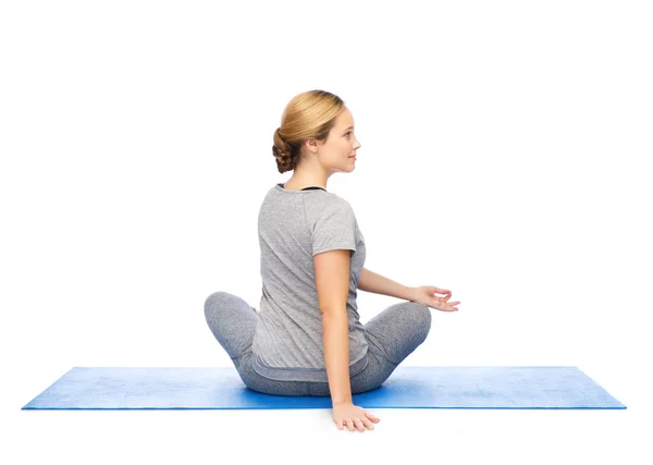 Woman making yoga in twist pose on mat — Stock Photo, Image