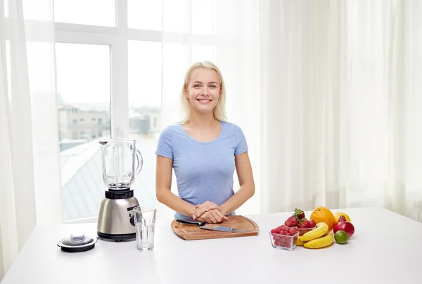 Mujer sonriente con licuadora y frutas en casa —  Fotos de Stock