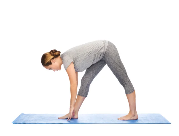 Žena dělat jógu intenzivní roztáhnout pozice na mat — Stock fotografie