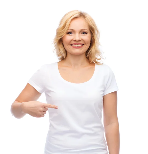 Beyaz t-shirt kendisine işaret içinde gülümseyen kadın — Stok fotoğraf