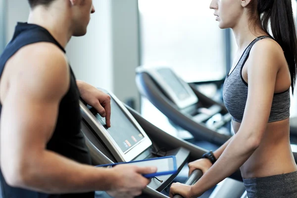 close up of woman with trainer on treadmill in gym