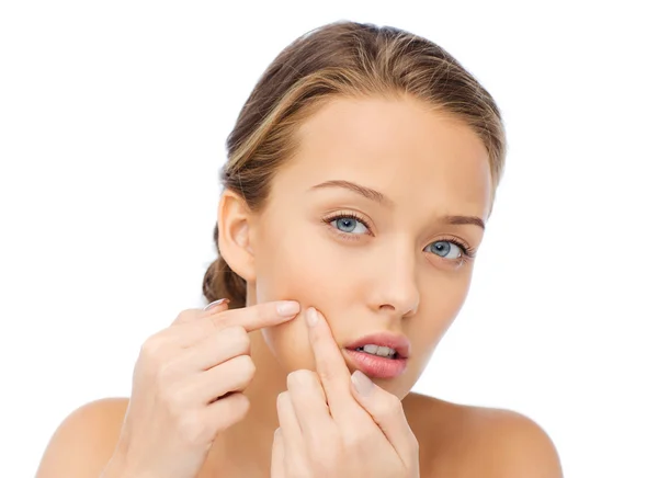Young woman squeezing pimple on her face — Stock Photo, Image