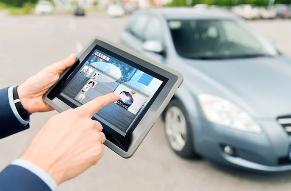 Primer plano de las manos con noticias en la tableta PC y el coche —  Fotos de Stock