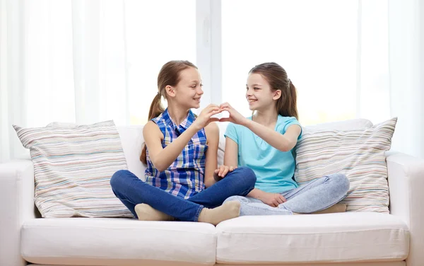 Niñas felices mostrando la forma del corazón signo de mano — Foto de Stock