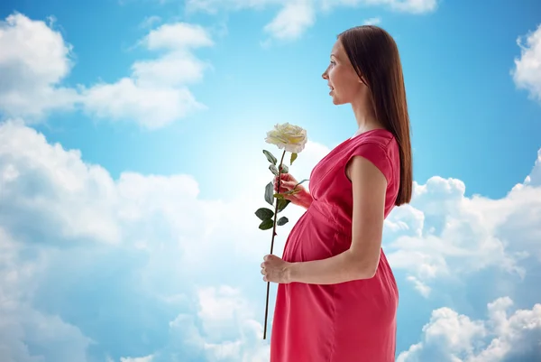 Szczęśliwa kobieta w ciąży z róży kwiat — Zdjęcie stockowe
