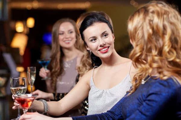 Mulheres felizes com bebidas no clube noturno — Fotografia de Stock