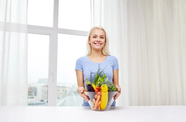 Jonge vrouw groenten thuis koken glimlachen — Stockfoto