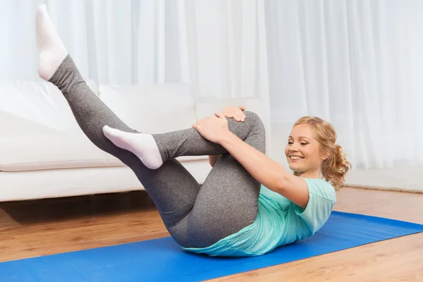 Mulher se exercitando no tapete em casa — Fotografia de Stock
